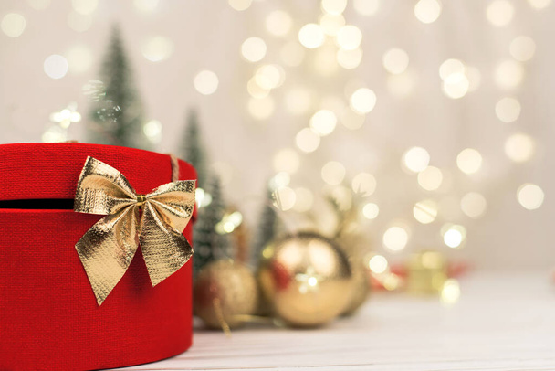 Christmas background , gift box with a Golden bow on the background of Christmas bokeh - Фото, зображення