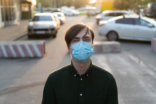 Bílý mladík v lékařské masce. Ochrana proti koronaviru. - Fotografie, Obrázek