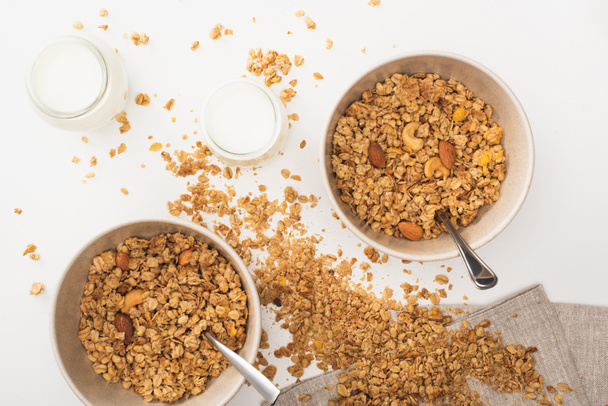vista superior de la deliciosa granola con nueces, yogur aislado en blanco - Foto, Imagen