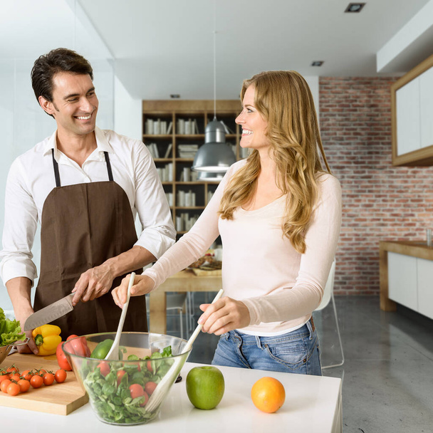 Young couple prepairing a healthy salad in a modern luxurious interior - Photo, Image