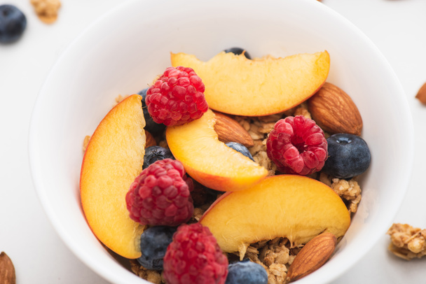 closeup of delicious granola with nuts, peach, blueberry and raspberry - Photo, Image