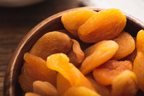 closeup of delicious dried apricots in wooden bowl - Photo, Image