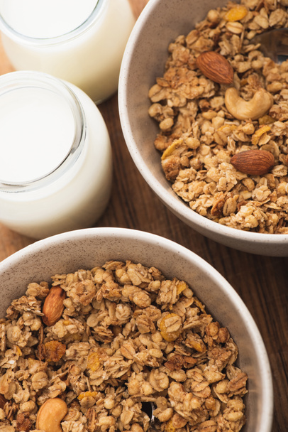closeup of delicious granola with nuts and yogurt on wooden board - Photo, Image