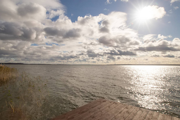 Прекрасна мирна вода озера Браслав в ідилічну погоду сонячний день і драматичне блакитне хмарне небо.. - Фото, зображення
