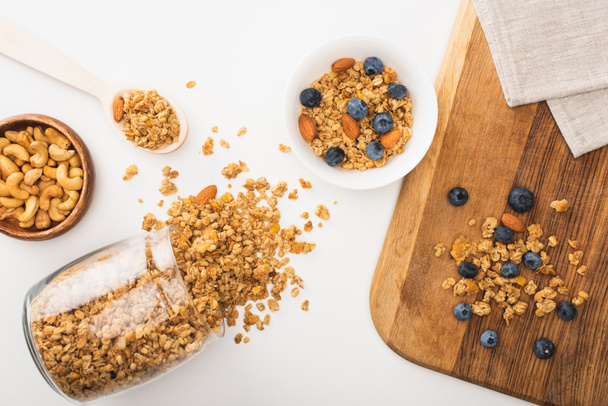vista superior de la deliciosa granola con nueces, arándanos y albaricoques secos aislados en blanco - Foto, imagen
