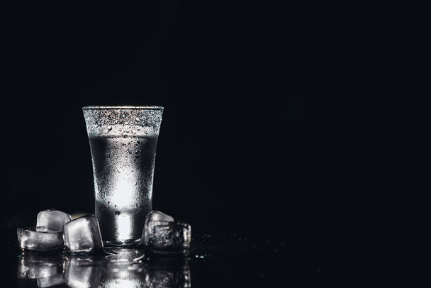 Vodka. Shots, glasses with vodka with ice .Dark background. Copy space .Selective focus - Fotoğraf, Görsel