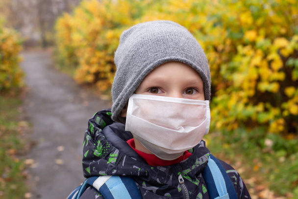the schoolboy in protective mask on the street - Foto, imagen