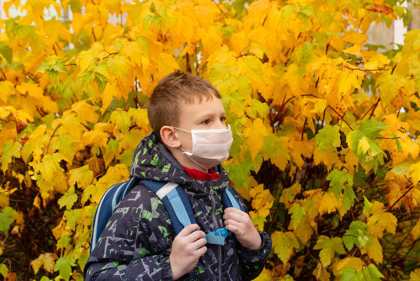 школьник в защитной маске на улице - Фото, изображение