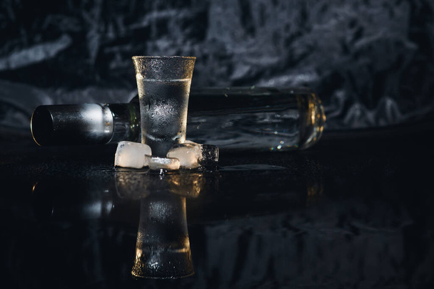 Vodka. Shots, glasses with vodka with ice .Dark background. Copy space .Selective focus - Фото, изображение