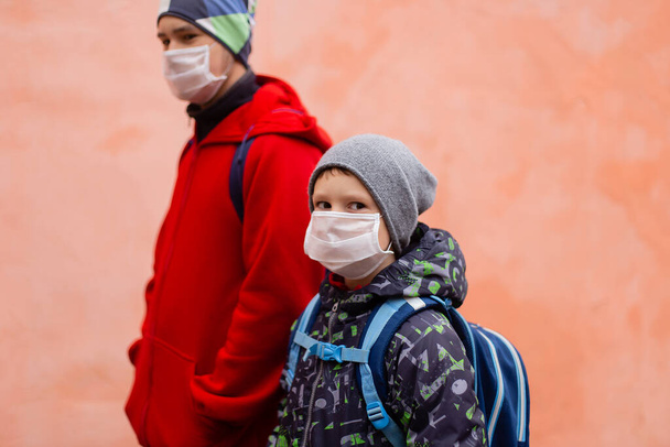 die Schulkinder in Schutzmasken auf der Straße - Foto, Bild