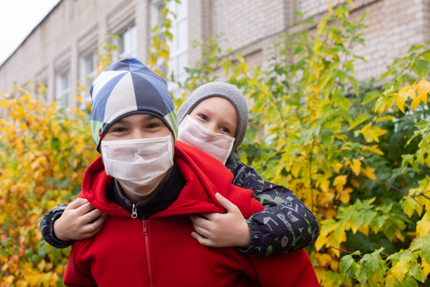die Schulkinder in Schutzmasken auf der Straße - Foto, Bild