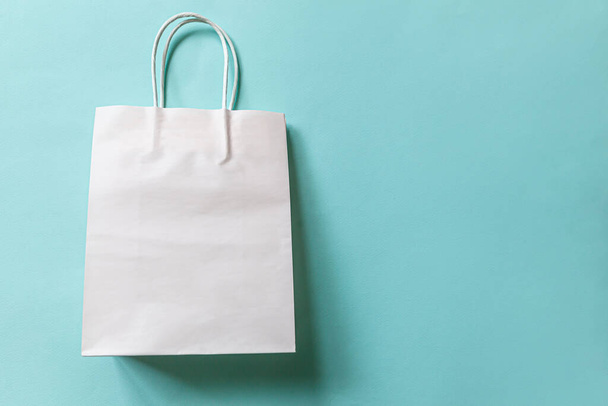 Einfach minimalistisch gestaltete Einkaufstasche isoliert auf blauem Pastellhintergrund. Shopaholic-Konzept für Online-Shopping oder Einkaufszentren. Black Friday Weihnachtsverkauf. Flache Lageansicht Kopierraum-Attrappe - Foto, Bild