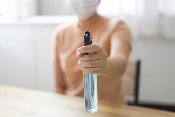 Vrouw die alcohol spuit Anti-Bacterial Sanitizer desinfecterende spray om Coronavirus of Covid-19 te voorkomen - Foto, afbeelding