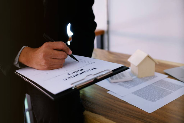 Un homme d'affaires signe un contrat avec un agent immobilier Concept de consultant et concept d'assurance habitation - Photo, image