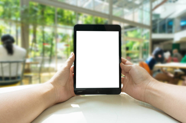 Vista recortada de las manos de la mujer sosteniendo la tableta con pantalla de espacio de copia en blanco para su mensaje de texto o contenido de información, mensaje de texto de lectura femenina en el bloc de notas durante en el entorno urbano - Foto, imagen