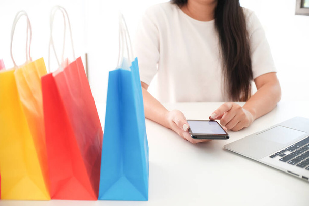 Vrouw en klein winkelwagentje met laptop voor internet online shopping concept - Foto, afbeelding