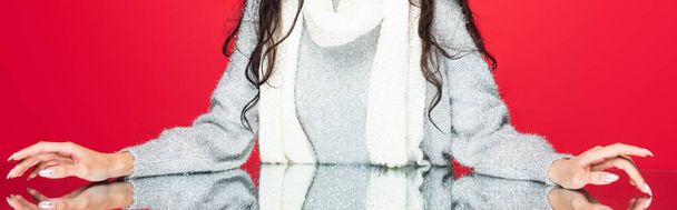 cropped view of woman in sweater and warm scarf isolated on red, banner - Photo, Image