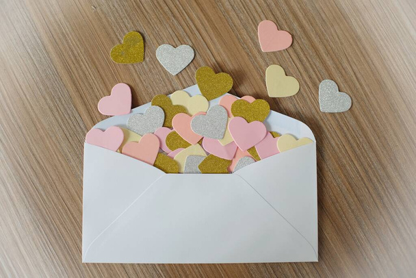 Valentinstag Liebesbrief. geöffneter Umschlag und viele Filzherzen. Leerer Kopierraum  - Foto, Bild