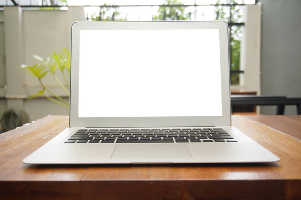 Laptop s prázdnou obrazovkou na dřevěném stole před kavárnou kavárny - technologický koncept. - Fotografie, Obrázek