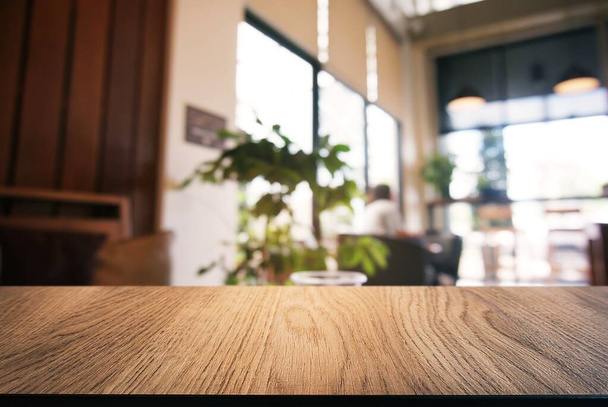 Üres fa asztal előtt elvont elmosódott háttér kávézó. lehet használni megjelenítésére vagy montázs a termékeket.Mock up megjelenítéséhez termék. - Fotó, kép