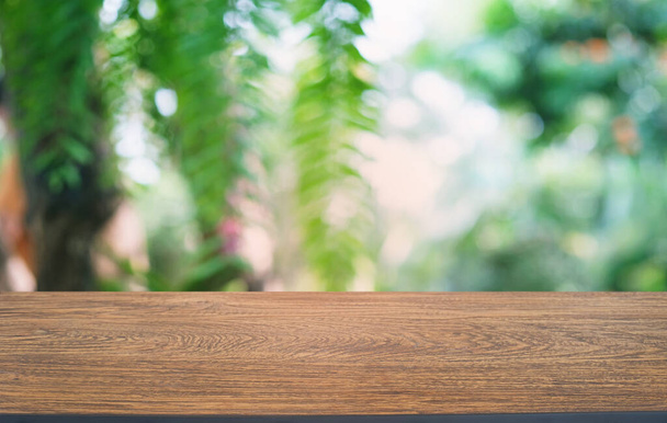 Lege donkere houten tafel voor abstracte wazig bokeh achtergrond van restaurant. kan worden gebruikt voor het weergeven of monteren van uw producten.Mock up voor de ruimte  - Foto, afbeelding