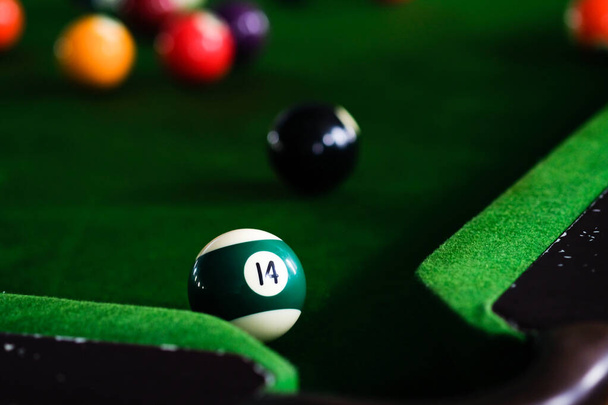 Männerhand und Cue-Arm spielen Snookerspiel oder bereiten sich darauf vor, Billardbälle auf einen grünen Billardtisch zu schießen. Bunte Snookerbälle auf grünem Fries - Foto, Bild