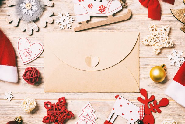 Top view of envelope on festive wooden background. Christmas toys and decorations. New Year time concept. - Photo, Image