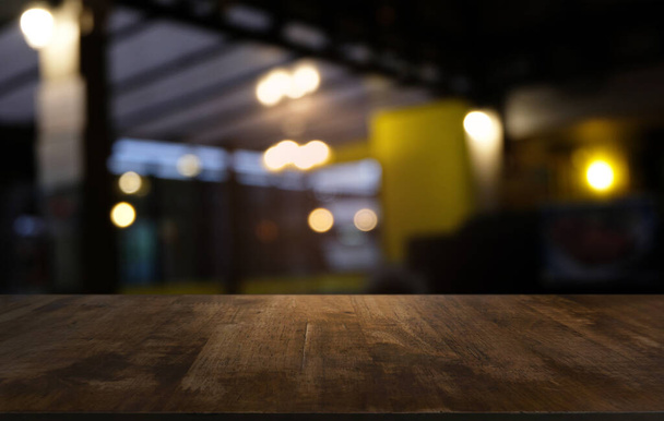 Empty dark wooden table in front of abstract blurred bokeh background of restaurant . can be used for display or montage your products.Mock up for space - Photo, Image
