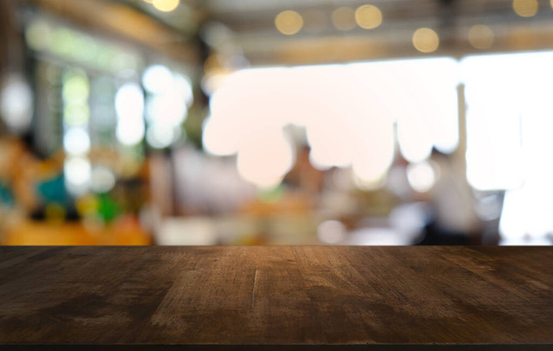 Restoranın soyut bulanık arka planının önündeki boş, siyah ahşap masa. Ürünlerinizi görüntülemek ya da montajlamak için kullanılabilir.  - Fotoğraf, Görsel
