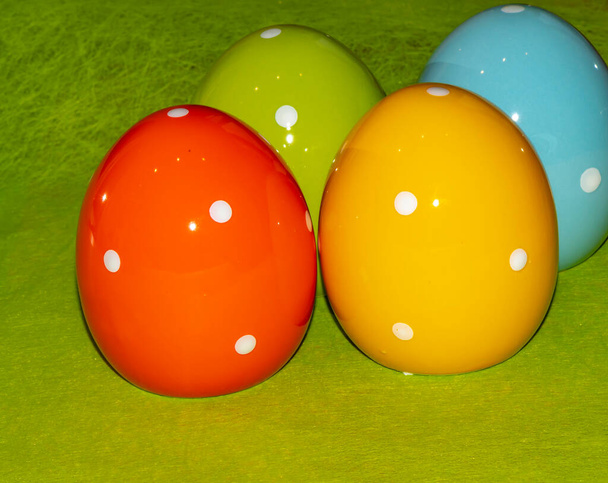 Huevos de Pascua de cerámica coloridos frente a un fondo verde - Foto, imagen