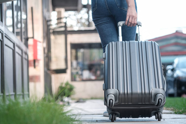 旅行者の女性荷物を運ぶ。スーツケース付きの観光ウォーキング｜トラベルライフスタイルコンセプト - 写真・画像