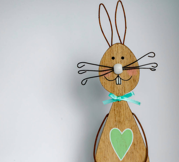Дерев'яний пасхальний кролик перед світлим тлом як основа для великодньої листівки
. - Фото, зображення