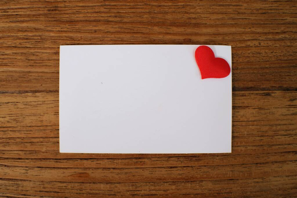 木製のテーブルの背景に空白のカード。バレンタインデーの挨拶とロマンチックなカップルのための愛の告白 - 写真・画像
