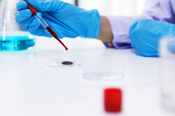 Coronavirus covid-19 'u tutan bilim adamı enfekte olmuş kan örneği tüpü. Kan örneği toplama tüpleri ve şırınga Coronavirus Covid-19 aşı araştırmalarıyla laboratuvardaki kanın DNA testi. - Fotoğraf, Görsel