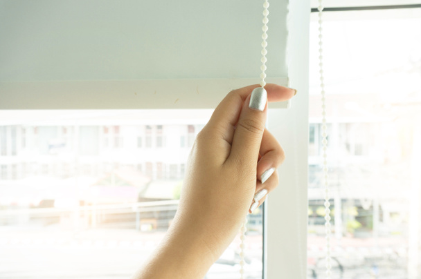 Window curtain shutter by Woman hands installing window blinds, closeup - Foto, Imagem