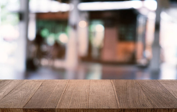 Mesa vacía de madera oscura frente al abstracto fondo borroso bokeh del restaurante. se puede utilizar para la exhibición o el montaje de sus products.Mock para arriba para el espacio - Foto, imagen