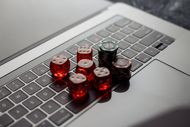 Online casino theme. Gambling chips and red dices on keyboard - Photo, Image