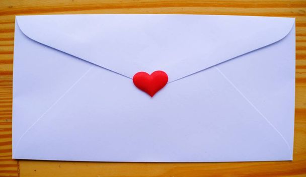 Sobre de carta de amor del día de San Valentín con corazones sobre fondo de madera. espacio de copia - Foto, imagen