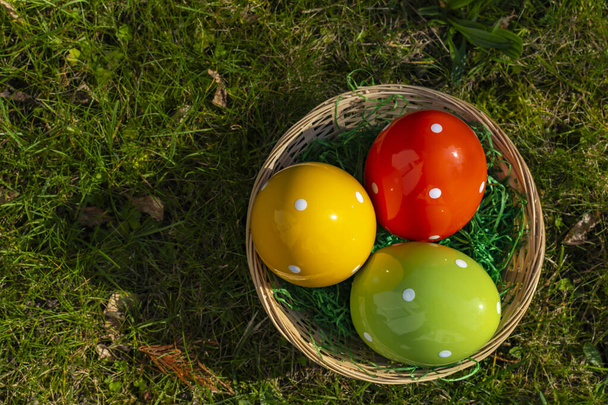 Œufs de Pâques en céramique colorée dans un panier sur une prairie. - Photo, image
