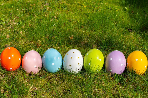 Барвисті керамічні великодні яйця в лінії на лузі
. - Фото, зображення