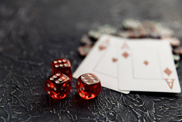 テーブルの上のポーカーオンラインまたはカジノのギャンブルのためのエースを持つチップ、 3つの赤いダイスとトランプ。オンラインカジノのコンセプト - 写真・画像