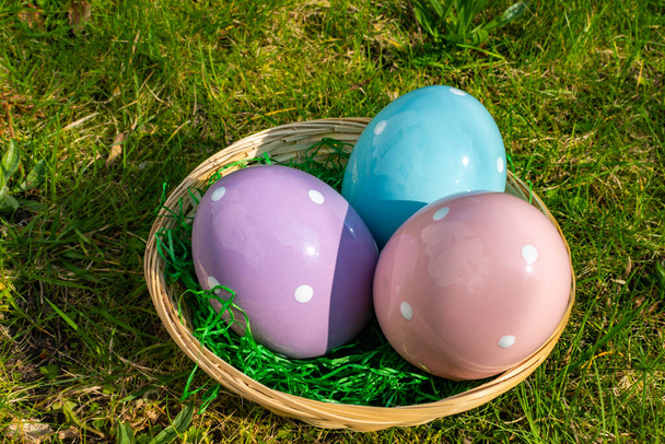 Uova di Pasqua di ceramica variopinte in un cesto su un prato. - Foto, immagini