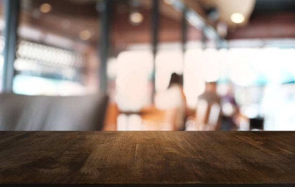 Table en bois sombre vide devant un fond bokeh abstrait flou du restaurant. peut être utilisé pour afficher ou monter vos produits.Maquette pour l'espace  - Photo, image