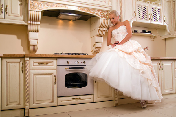 Attractive bride sitting in the kitchen - Zdjęcie, obraz