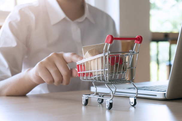 Woman forefinger pushing small shopping cart with Internet online shopping concept - Foto, imagen