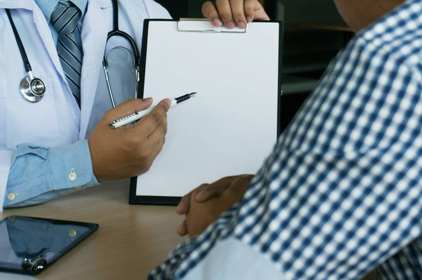 primer plano del paciente y el médico tomando notas o médico profesional en la entrevista bata de uniforme blanco. - Foto, Imagen