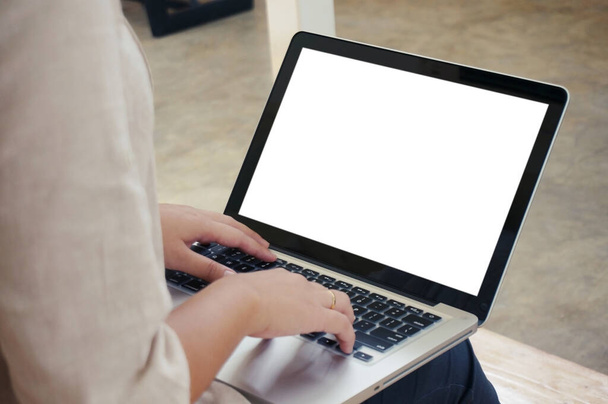 Случайная деловая женщина работает в Интернете на ноутбуке, который рука на клавиатуре в ее доме Изолированный экран в ноутбуке - Фото, изображение