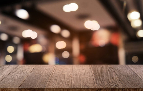 Mesa vacía de madera oscura frente al abstracto fondo borroso bokeh del restaurante. se puede utilizar para la exhibición o el montaje de sus products.Mock para arriba para el espacio - Foto, imagen