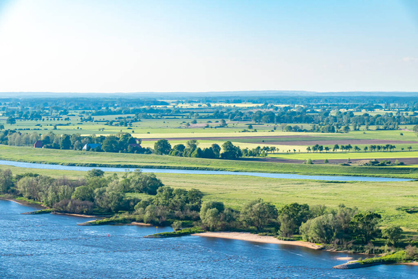 Uitzicht over de Elbauen in Nedersaksen, Duitsland. U ziet een landschap met velden, weiden en de rivier de Elbe. - Foto, afbeelding