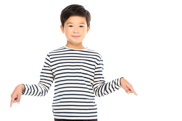 Asian kid looking at camera and pointing with fingers down isolated on white - Photo, Image